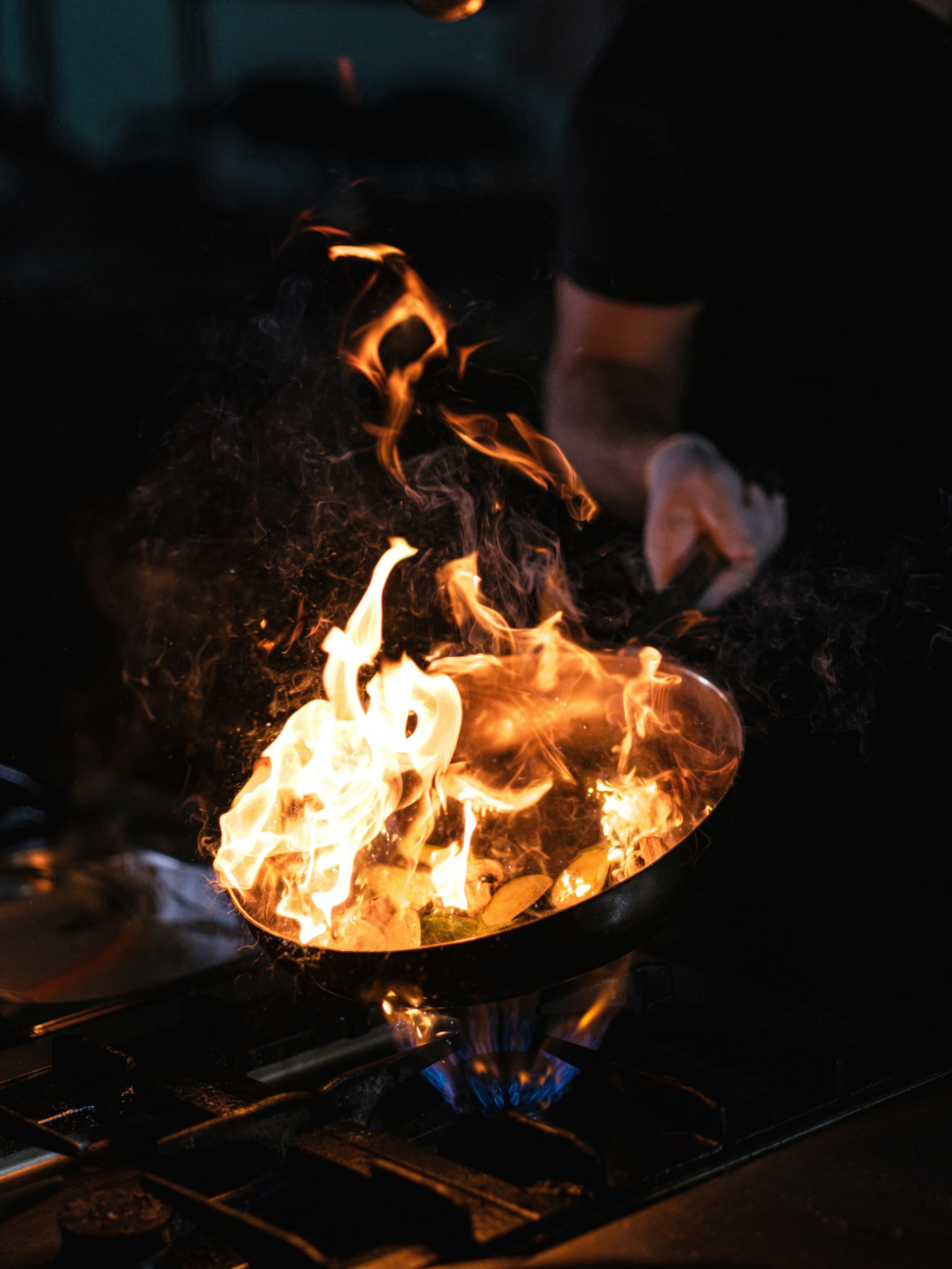 Fire rising from a wok in the Sanbay Fusion kitchen